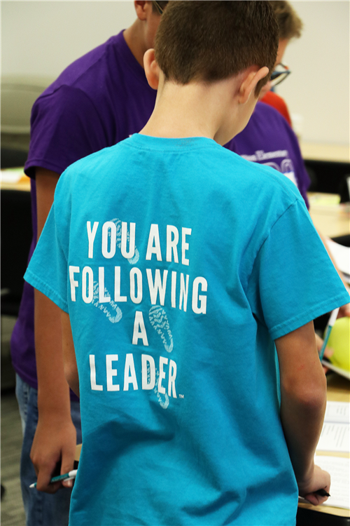 Back of student's shirt says "You are following a leader"